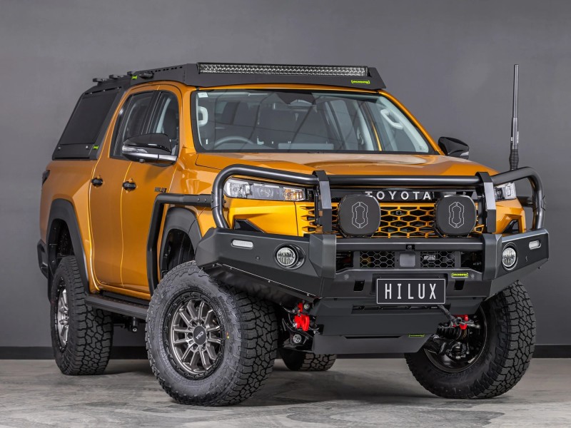 toyota hilux n90 2026 sunglow orange with ironman 4x4 deluxe bull bar front thee quarter angle