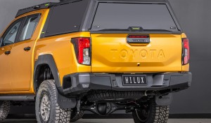 toyota hilux n90 2026 sunglow orange with ironman 4x4 raid canopy tradie pack rear three quarter angle