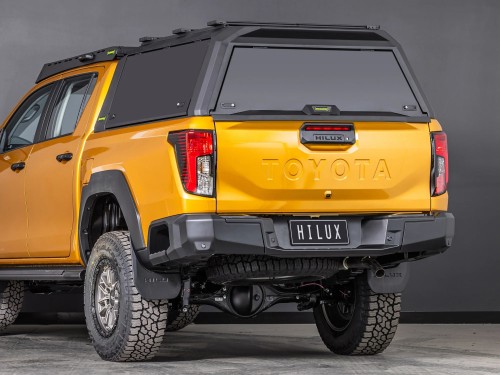 toyota hilux n90 2026 sunglow orange with ironman 4x4 raid canopy tradie pack rear three quarter angle